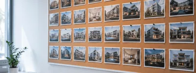 Mural de cortiça em um escritório coberto por dezenas de fotos de fachadas de imóveis diferentes, lado a lado, representando uma carteira grande de propriedades administradas