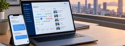 Notebook e celular sobre mesa de café exibindo painel de reservas e mensagens automáticas, com uma cidade grande desfocada pela janela ao fundo